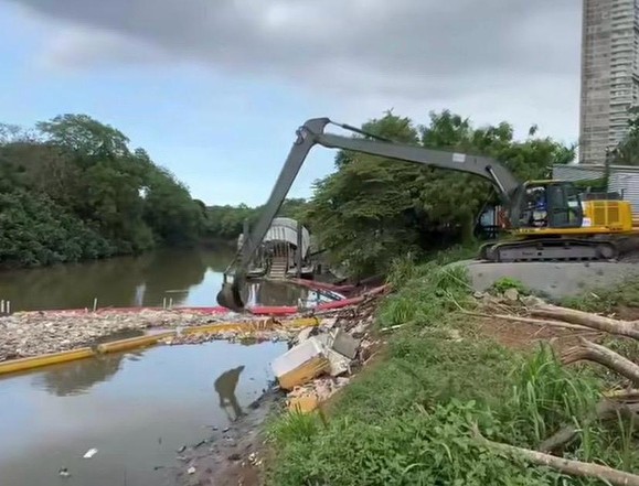 Excavadora retirando residuos de un río durante una jornada de recuperación ambiental